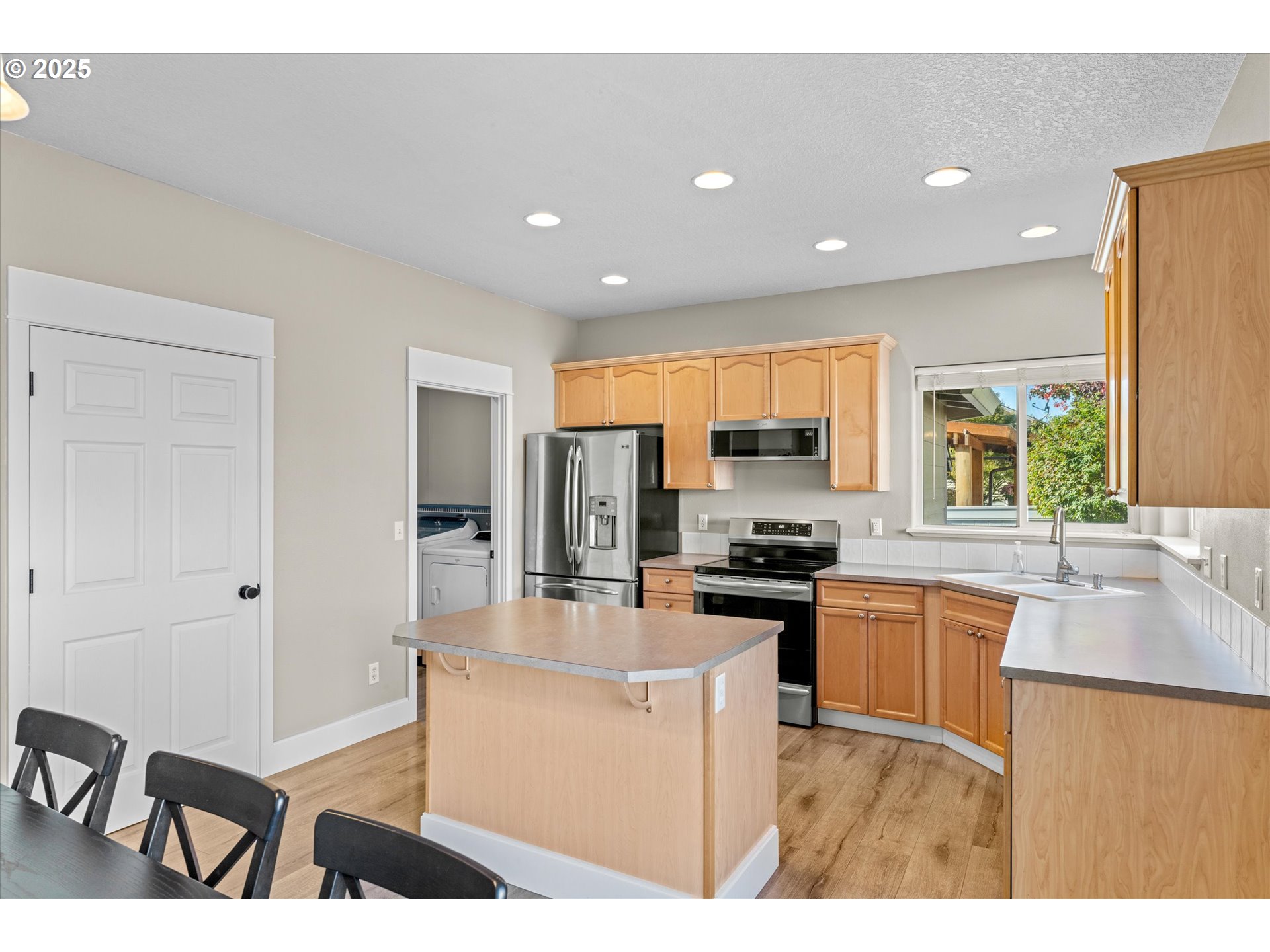 6475 Southeast 33rd Way Gresham, OR 97080 - Photo 15 of 47 a kitchen with stainless steel appliances granite countertop a stove top oven a sink a refrigerator and white cabinets with wooden floor