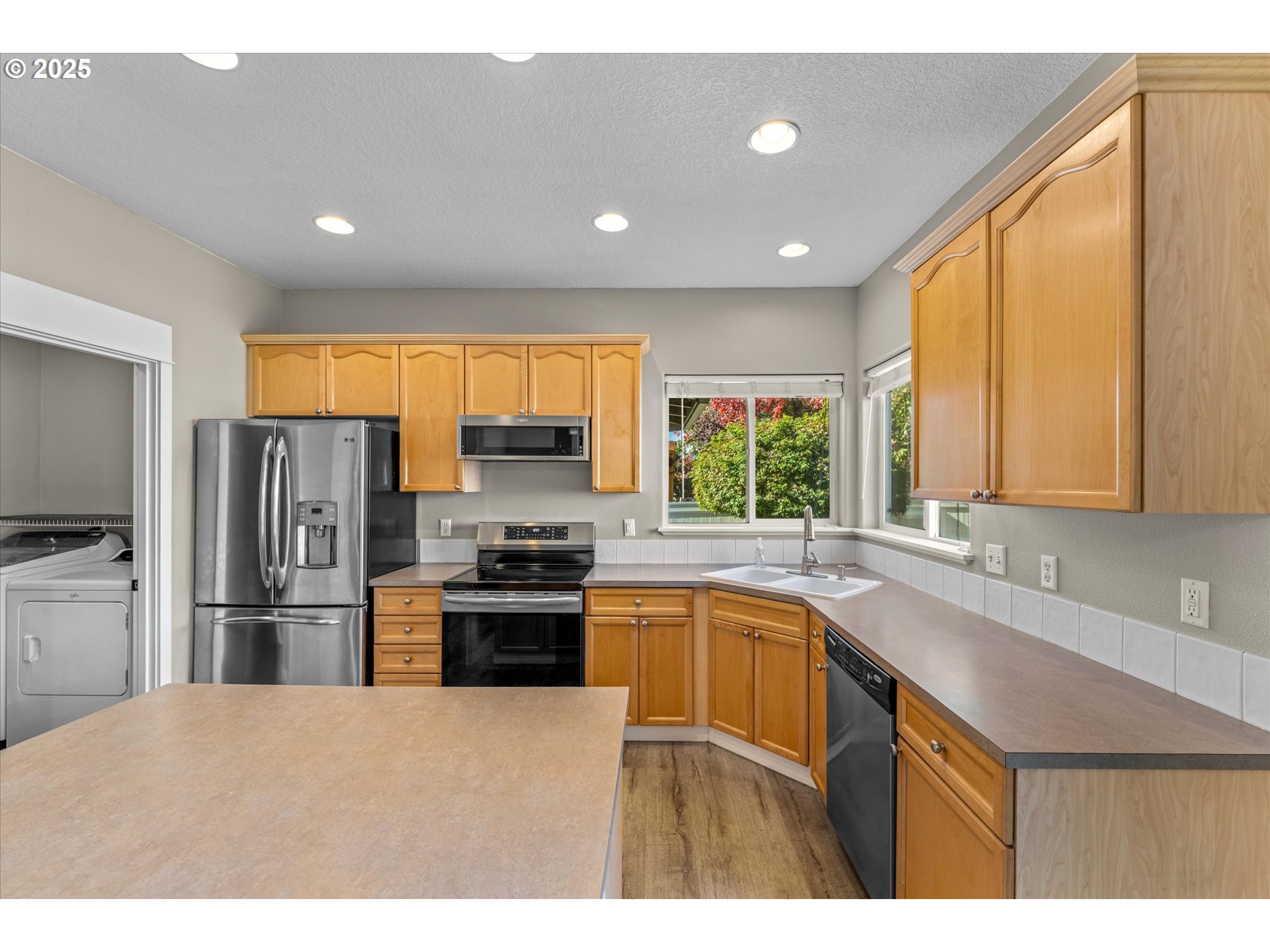 6475 Southeast 33rd Way Gresham, OR 97080 - Photo 16 of 47 a kitchen with stainless steel appliances granite countertop a sink a stove a refrigerator cabinets and a window