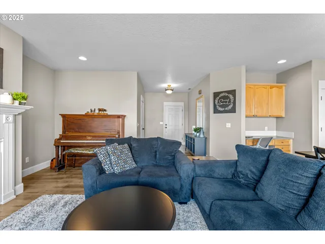 a living room with couches a dining table chairs and kitchen view