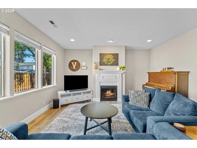a living room with furniture a fireplace and a flat screen tv