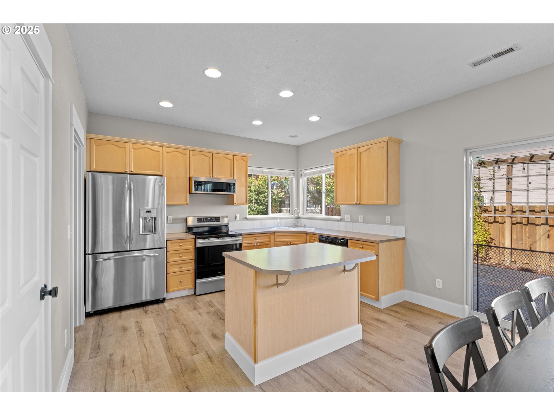6475 Southeast 33rd Way Gresham, OR 97080 - Photo 9 of 47 a kitchen with a refrigerator a stove top oven a sink dishwasher and white cabinets with wooden floor