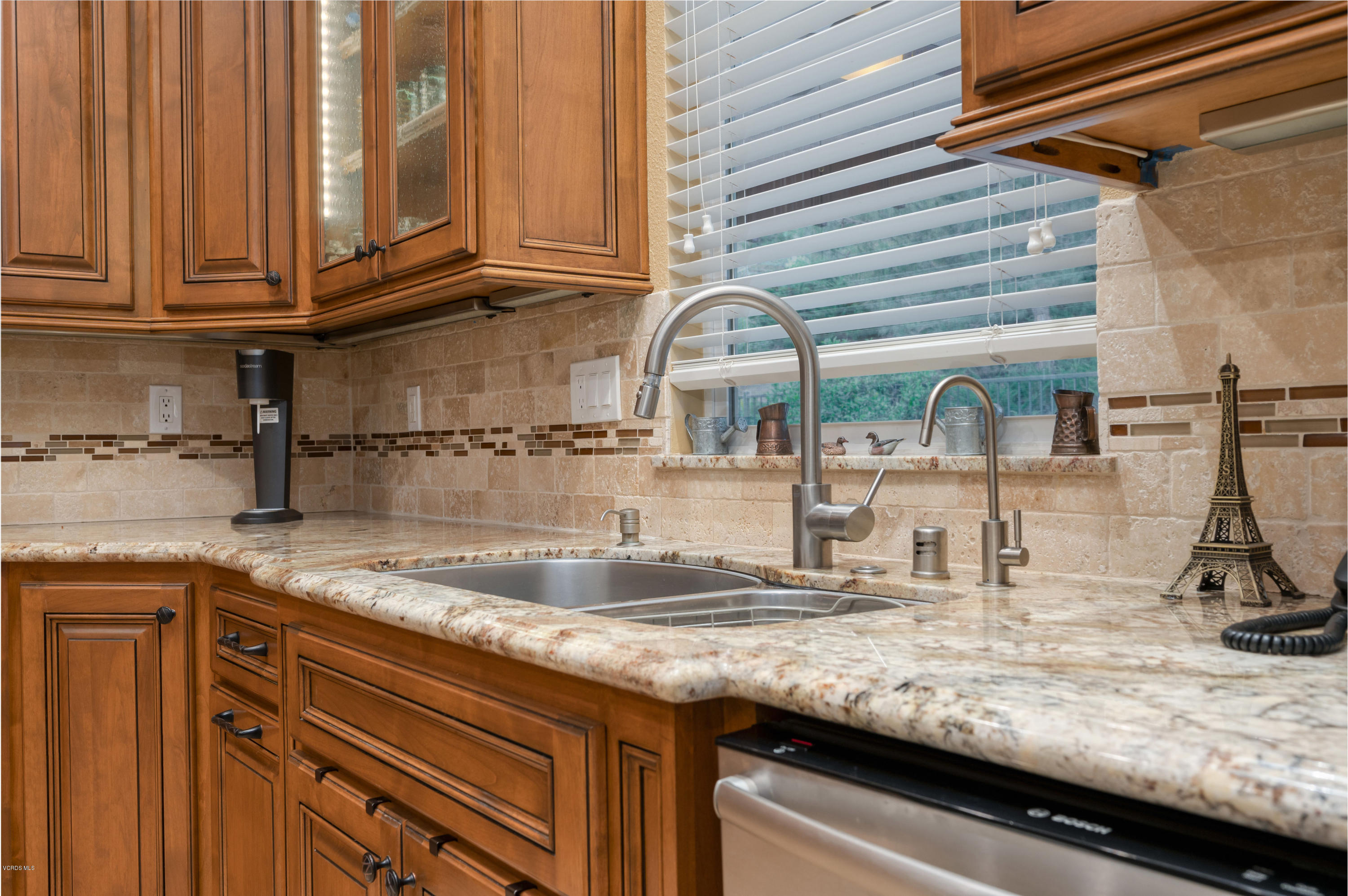 6945 Shadow Wood Drive Moorpark, CA 93021 - Photo 12 of 42 a kitchen with granite countertop a sink a stove and cabinets