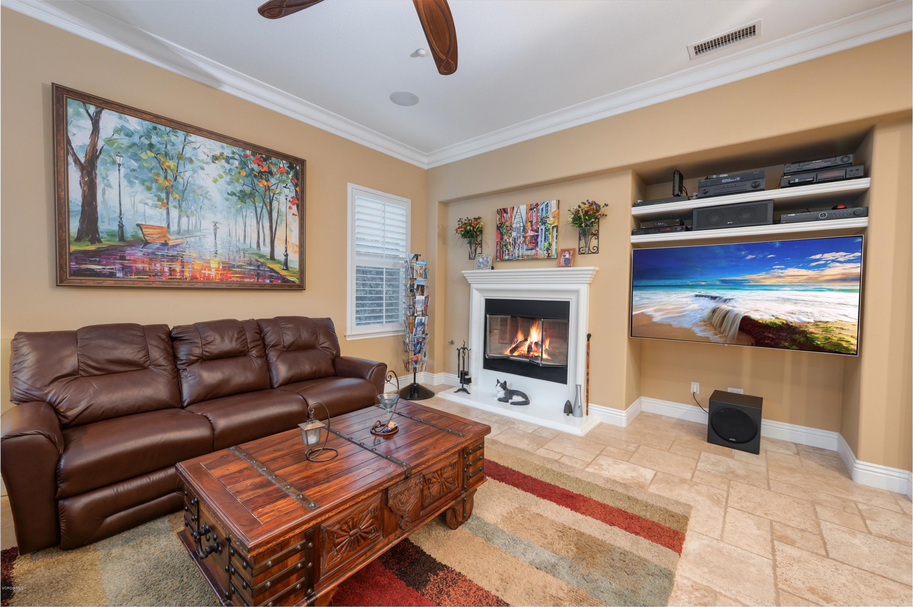 6945 Shadow Wood Drive Moorpark, CA 93021 - Photo 19 of 42 a living room with furniture a flat screen tv and a fireplace