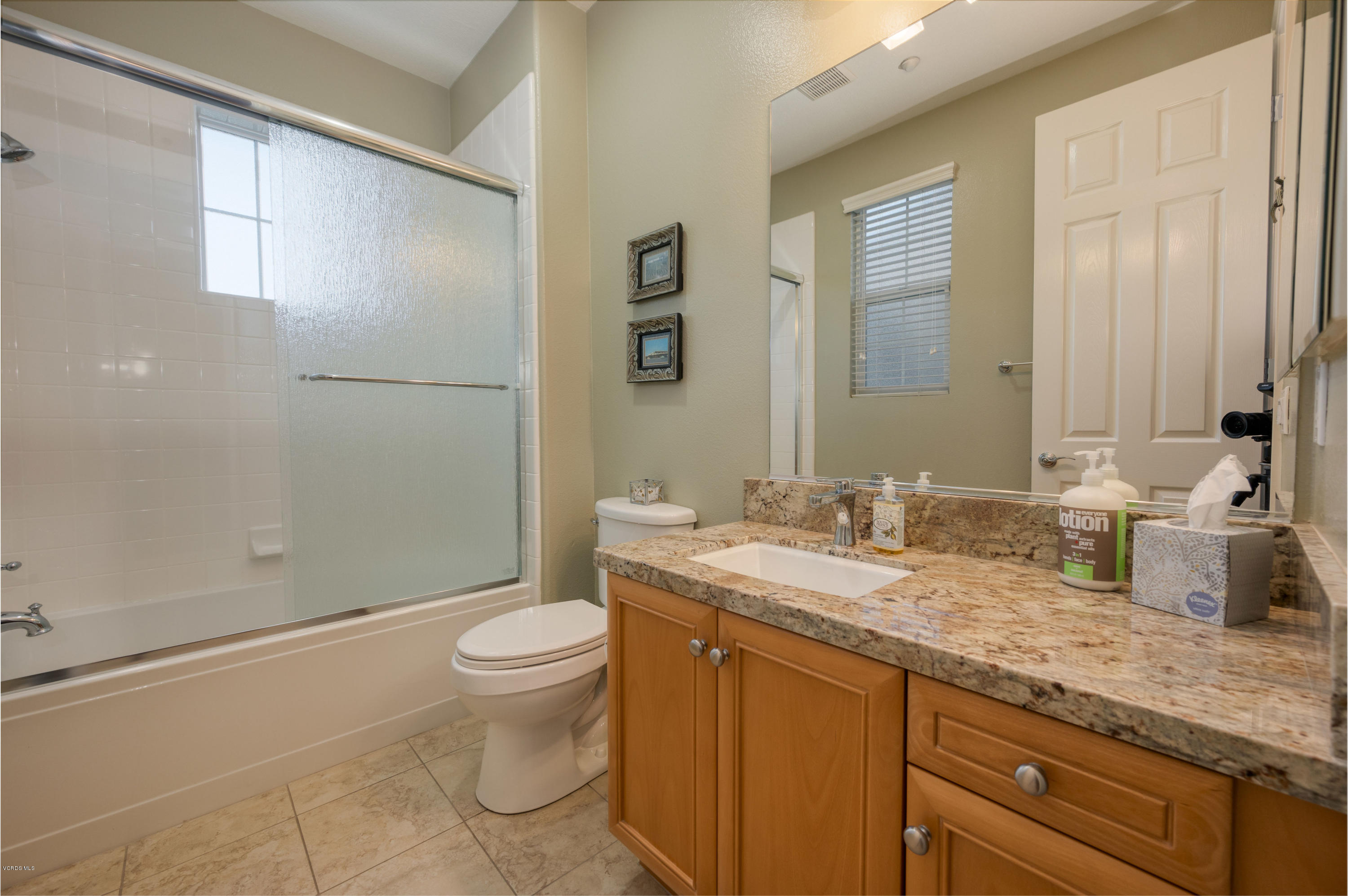 6945 Shadow Wood Drive Moorpark, CA 93021 - Photo 31 of 42 a bathroom with a granite countertop sink a toilet and a shower