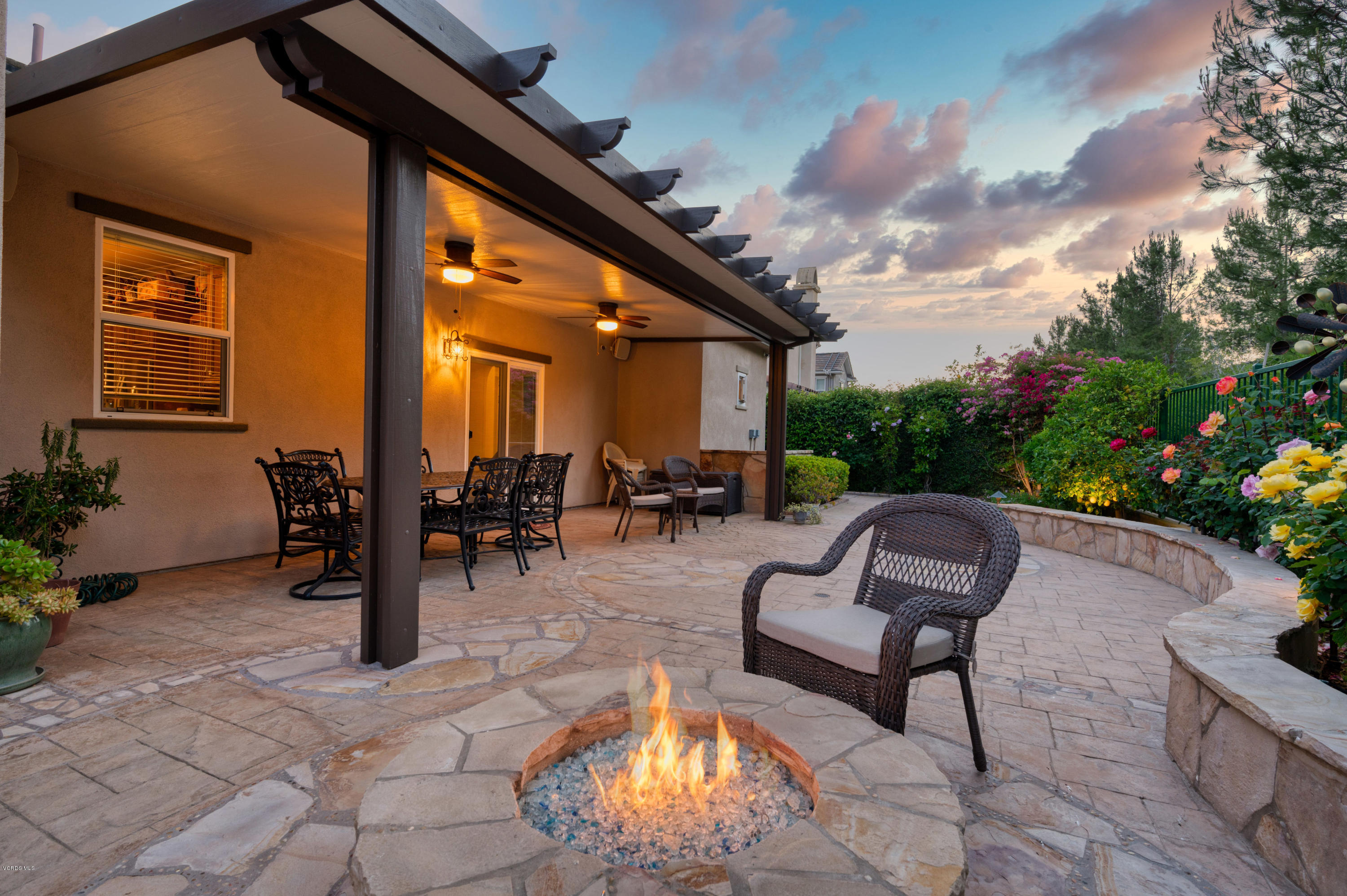 6945 Shadow Wood Drive Moorpark, CA 93021 - Photo 40 of 42 a view of a patio with dining table and chairs with a fire pit