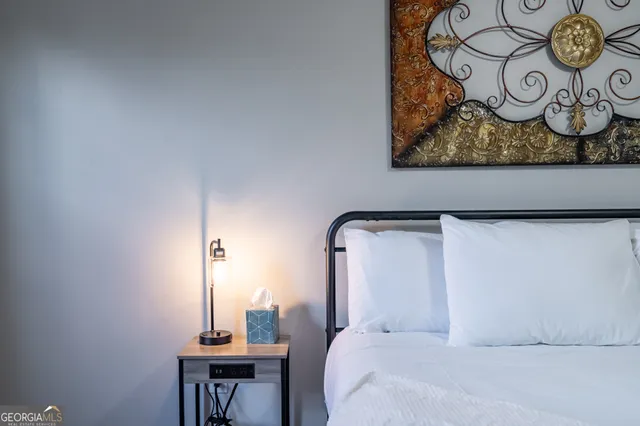 a bedroom with a bed and painting on the wall