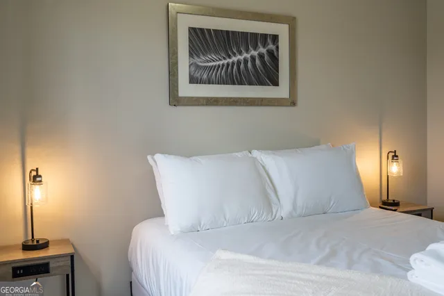 a bed room with a bed and a painting on the wall