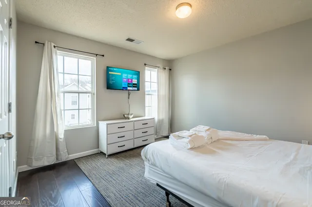 a bedroom with a bed and a flat screen tv