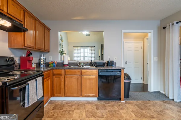a kitchen with stainless steel appliances granite countertop a stove a sink dishwasher and a refrigerator