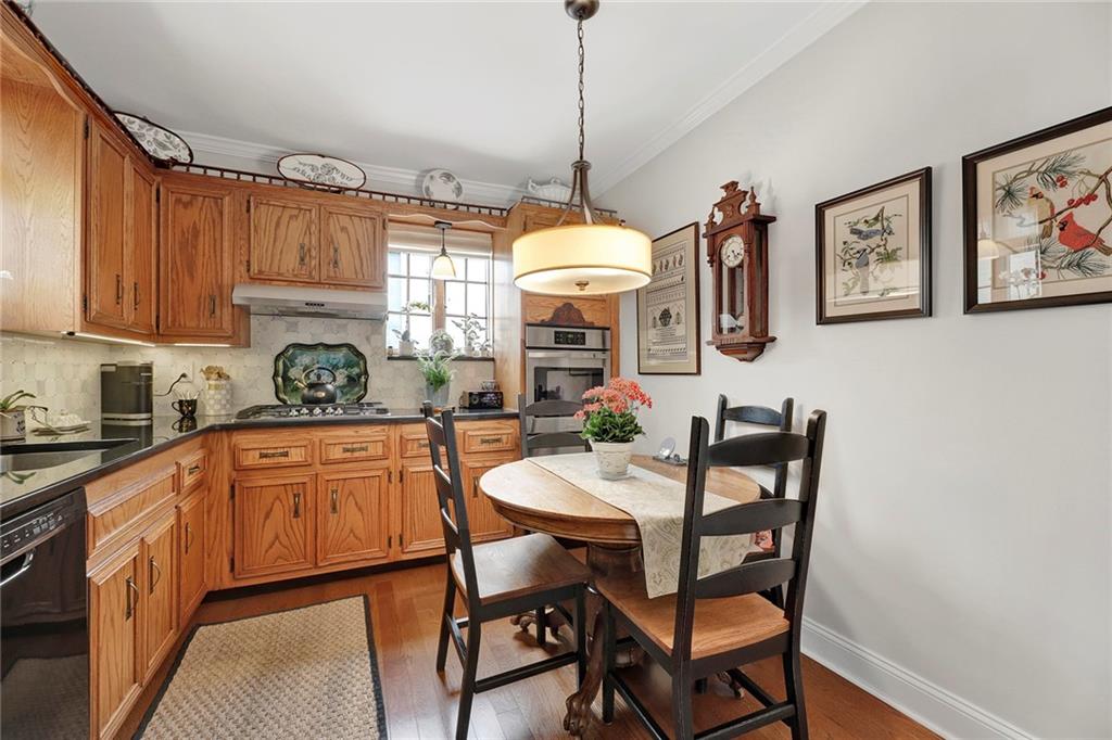 90 MacKay Place Brooklyn, NY 11209 - Photo 13 of 32 a kitchen with stainless steel appliances granite countertop a stove top oven a sink a dining table and chairs with wooden floor