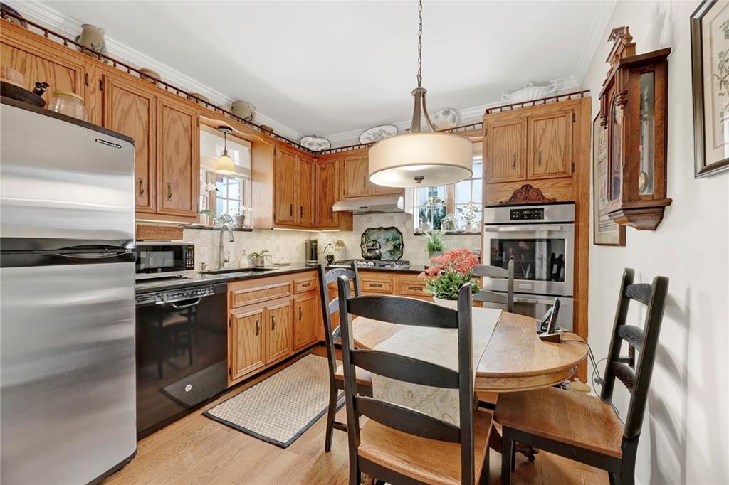 90 MacKay Place Brooklyn, NY 11209 - Photo 14 of 32 a kitchen with a refrigerator a stove a sink dishwasher a dining table and chairs with wooden floor