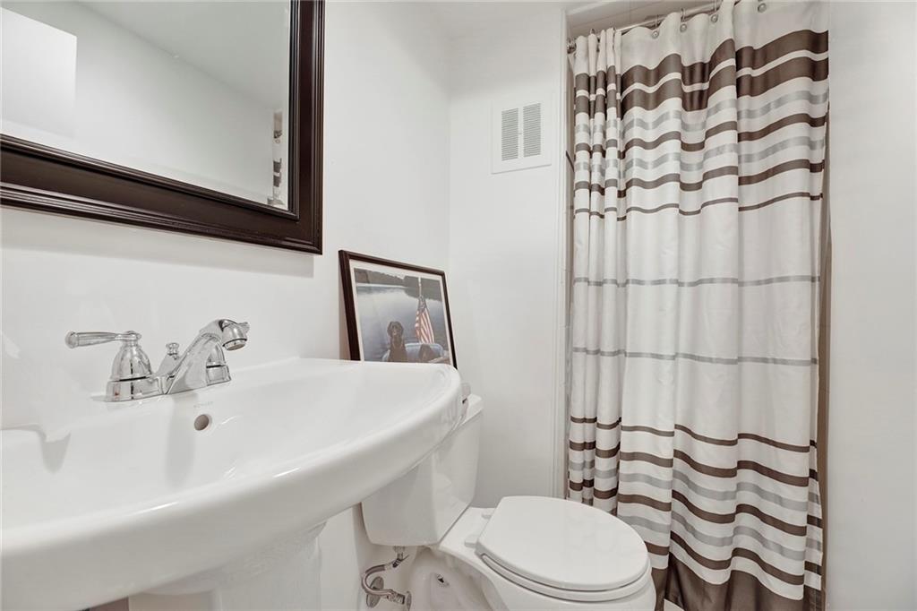 90 MacKay Place Brooklyn, NY 11209 - Photo 29 of 32 a bathroom with a sink a toilet and shower curtain