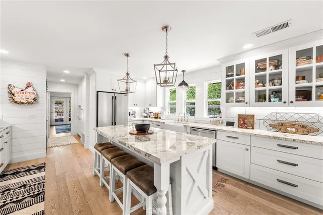 a large kitchen with granite countertop a sink a counter space appliances and cabinets