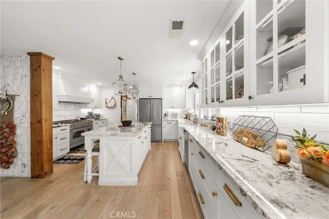 a large kitchen with stainless steel appliances granite countertop a stove and a sink