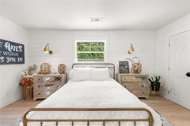 a view of a hallway with wooden floor and a potted plant