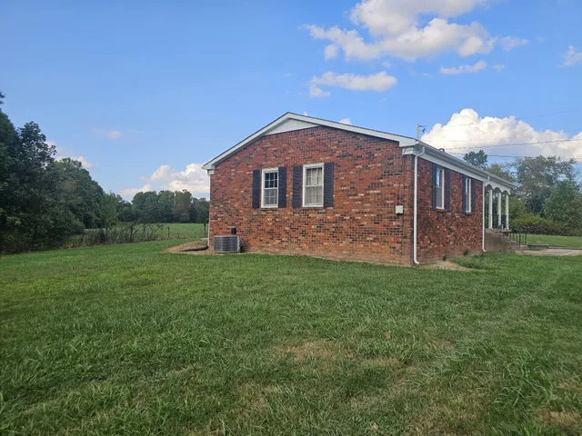 a view of a brick house with a yard