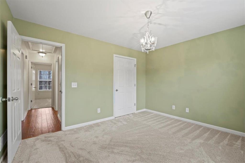 1218 Morgans Run Monroe, GA 30656 - Photo 21 of 39 a bedroom with a bed and a chandelier