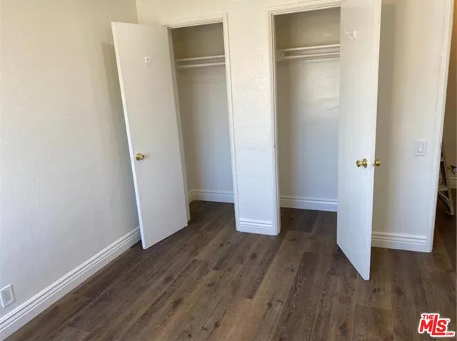 an empty room with wooden floor and entrance
