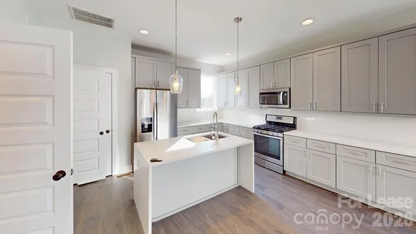 a kitchen with a stove a sink and a microwave