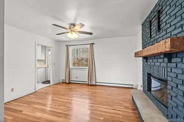 a view of a livingroom with a fireplace and a chandelier fan
