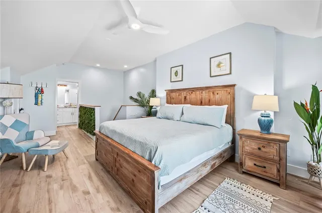 a bedroom with a large bed and a potted plant