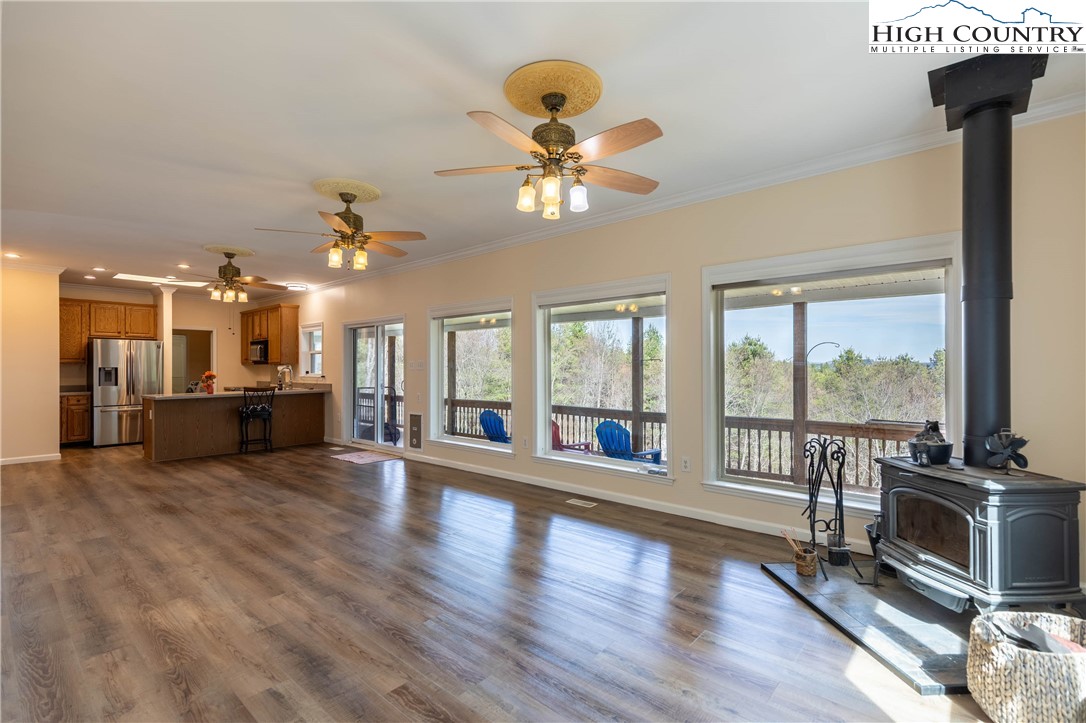 449 Meadow Ridge Drive Jefferson, NC 28640 - Photo 11 of 37 a view of an empty room with wooden floor fridge and a fireplace