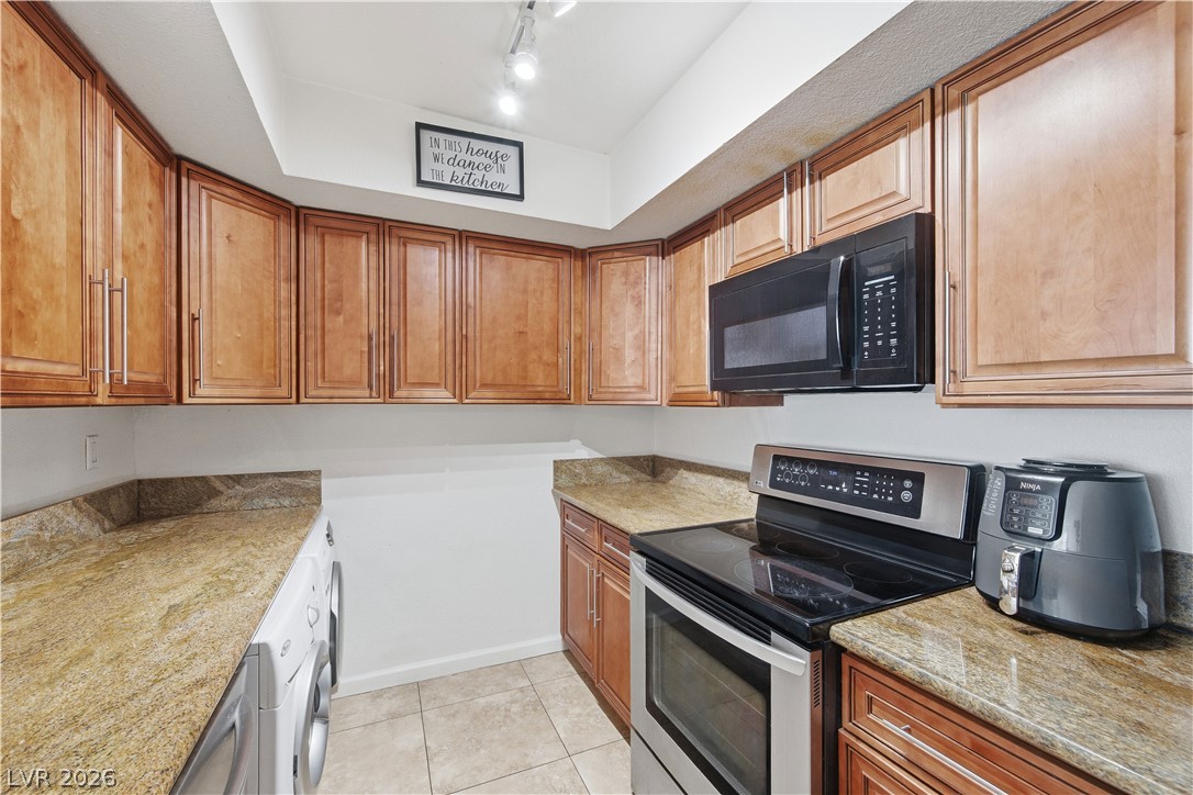2838 Geary Place, Unit 4017 Las Vegas, NV 89109 - Photo 11 of 31 Thanks to the tile flooring, this kitchen is a breeze to keep tidy, whether you’re prepping quick snacks or full dinners.