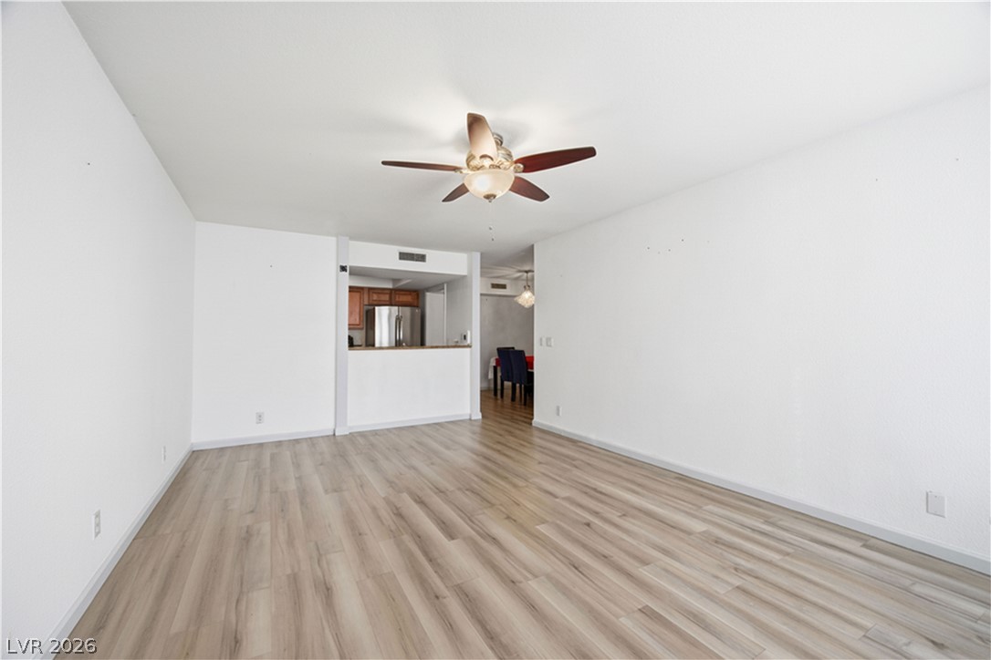 2838 Geary Place, Unit 4017 Las Vegas, NV 89109 - Photo 3 of 31 Step into this welcoming living room featuring light-toned luxury plank flooring and a convenient kitchen pass-through that keeps everyone connected.