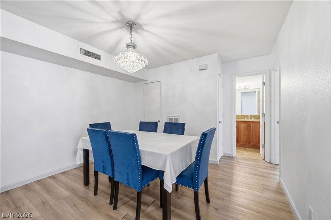 2838 Geary Place, Unit 4017 Las Vegas, NV 89109 - Photo 6 of 31 A bright dining space with a beautiful chandelier and two closets that offer flexible storage that help keep everything organized.