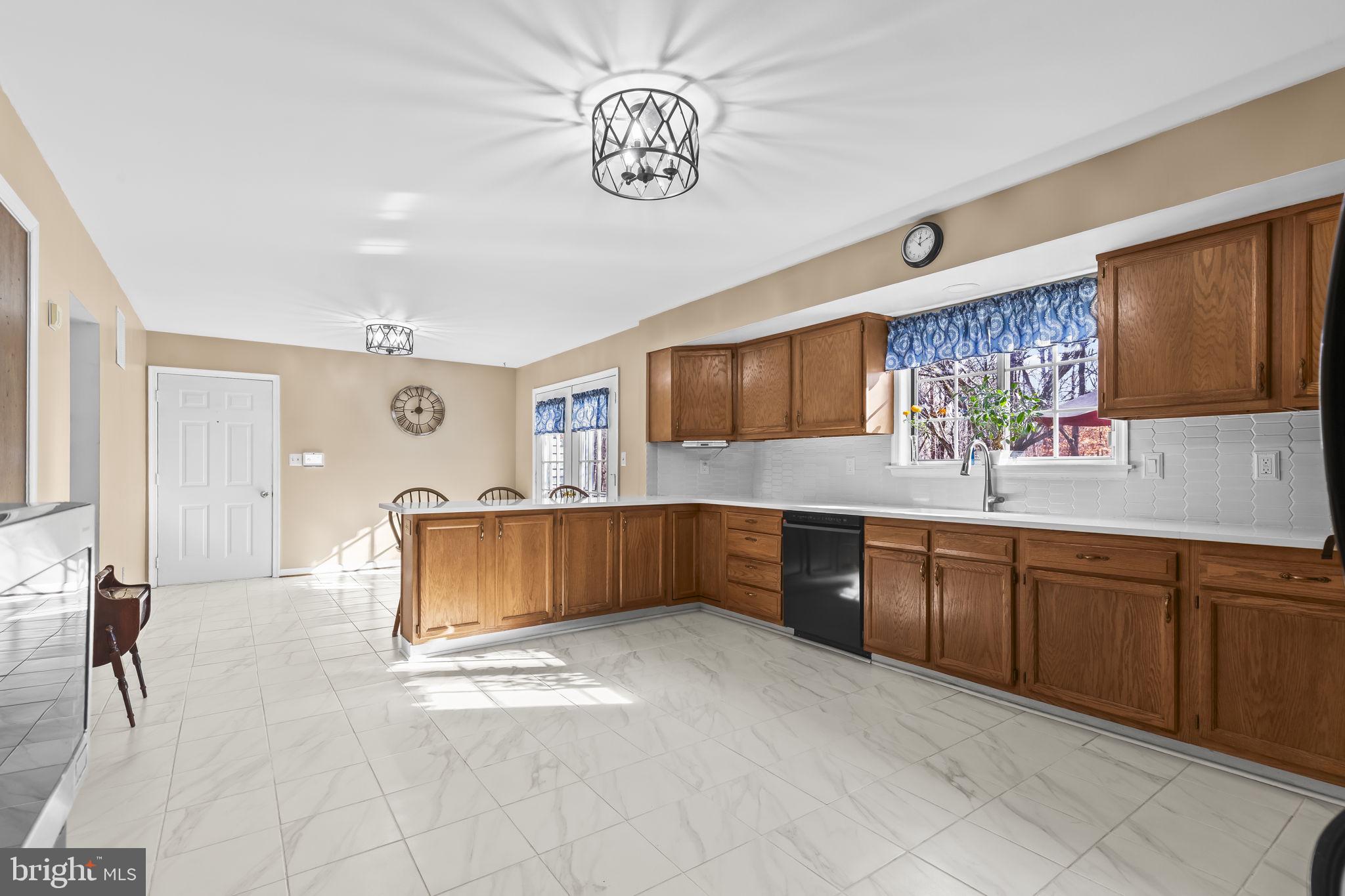 213 King James Road Upper Marlboro, MD 20774 - Photo 11 of 39 a kitchen with stainless steel appliances granite countertop a refrigerator a sink dishwasher a dining table and chairs with wooden floor