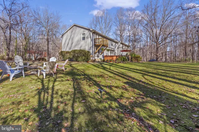 a view of a big house with a big yard and large trees