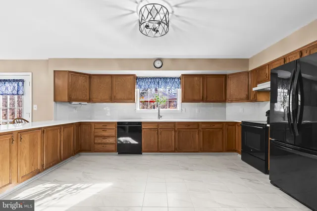 a kitchen with stainless steel appliances granite countertop a stove refrigerator and cabinets