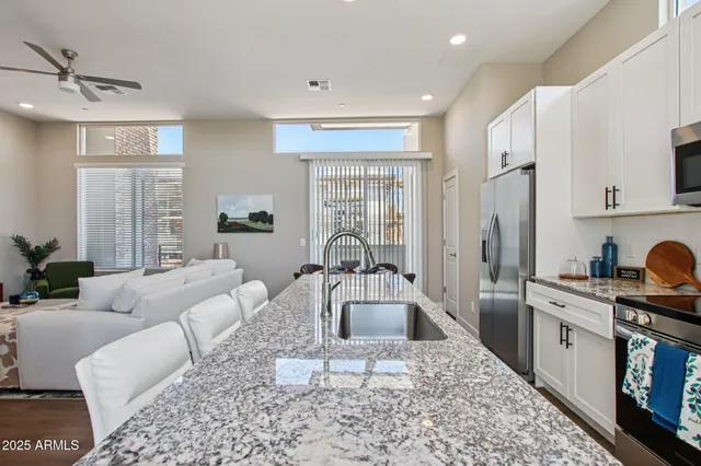 a kitchen with granite countertop a sink counter top space and stainless steel appliances