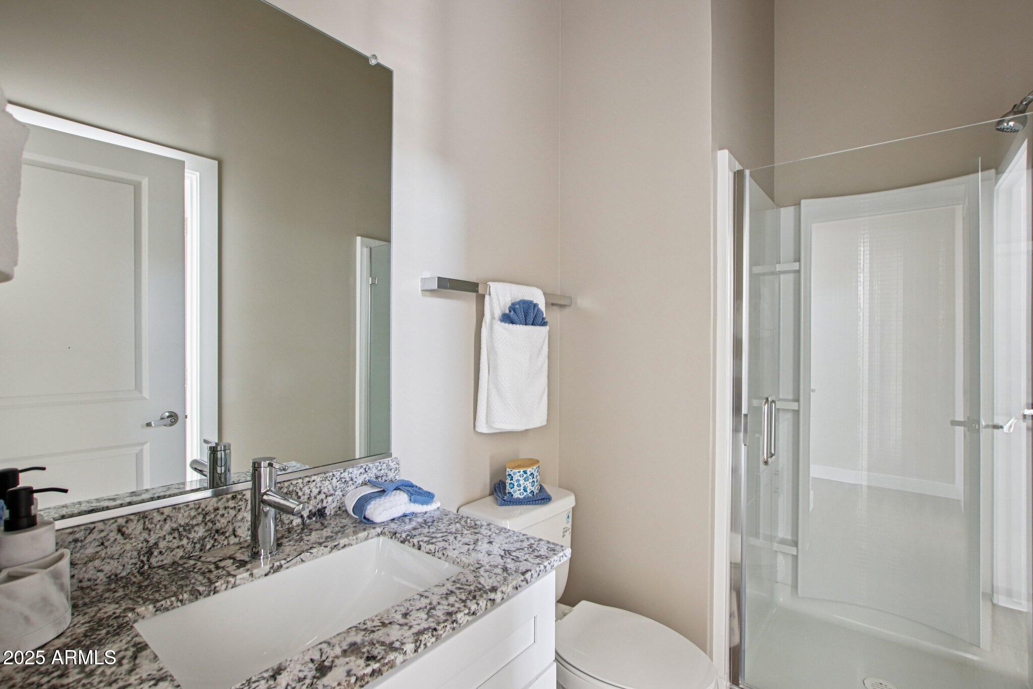1927 South Recker Road, Unit 175 Mesa, AZ 85206 - Photo 21 of 34 a bath room with a granite countertop toilet and a sink
