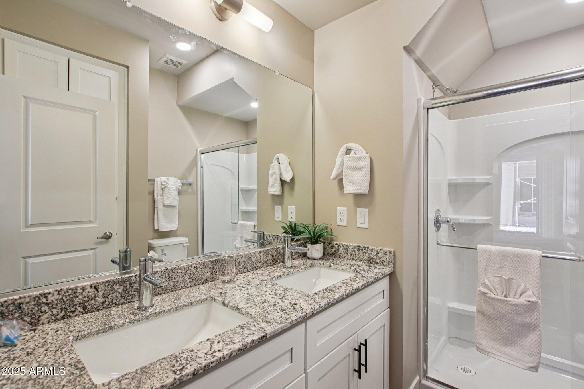 1927 South Recker Road, Unit 175 Mesa, AZ 85206 - Photo 29 of 34 a bathroom with a granite countertop double vanity sink and a mirror