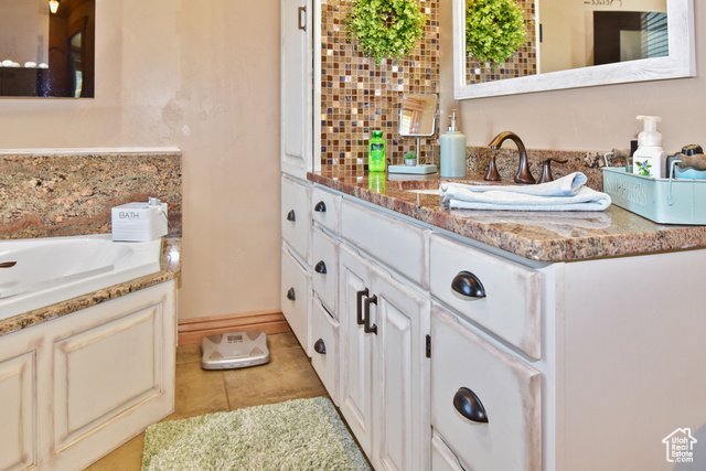 1500 Fish Creek Road Bancroft, ID 83217 - Photo 11 of 45 Bathroom with a garden tub, light tile patterned floors, backsplash, and double vanity