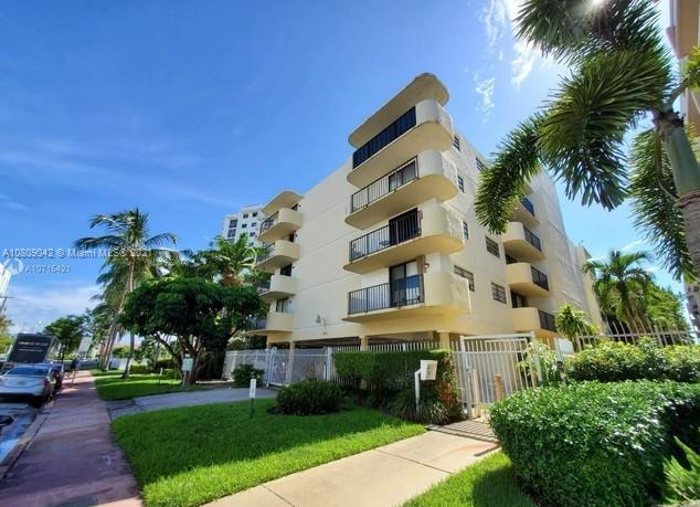 1673 Bay Road, Unit 303 Miami Beach, FL 33139 - Photo 1 of 16 a front view of a multi story building with yard
