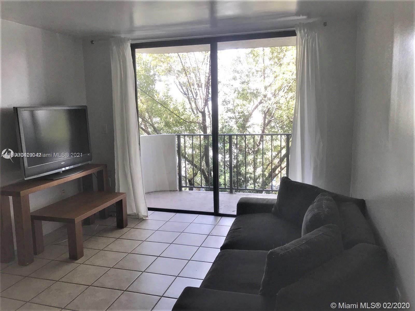 1673 Bay Road, Unit 303 Miami Beach, FL 33139 - Photo 5 of 16 a living room with furniture and a flat screen tv