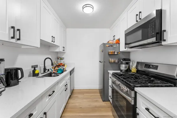 a kitchen with stainless steel appliances a sink a stove and cabinets