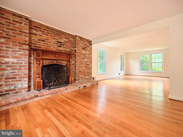 an empty room with fireplace and windows