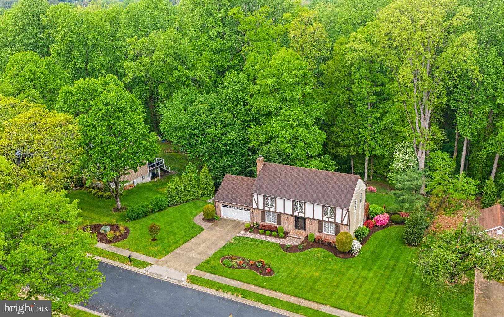 a view of a house with a big yard and large trees