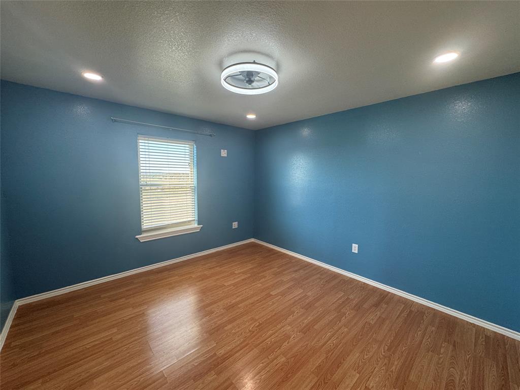 528 County Road 4227 Decatur, TX 76234 - Photo 11 of 22 an empty room with wooden floor and windows