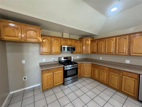 a kitchen with stainless steel appliances granite countertop a stove sink and cabinets