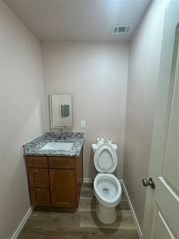 a bathroom with a granite countertop toilet and a sink