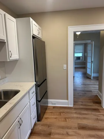 a kitchen with granite countertop a refrigerator and a sink