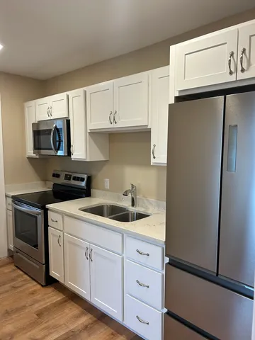 a kitchen with a refrigerator sink and cabinets