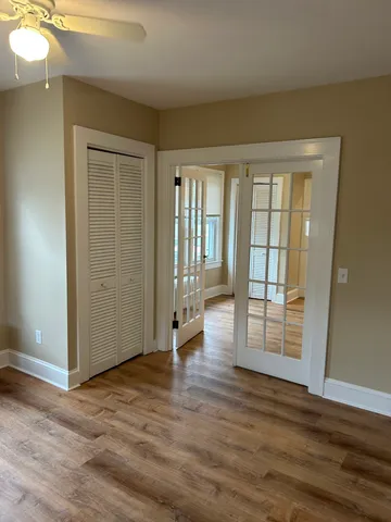 an empty room with wooden floor and windows