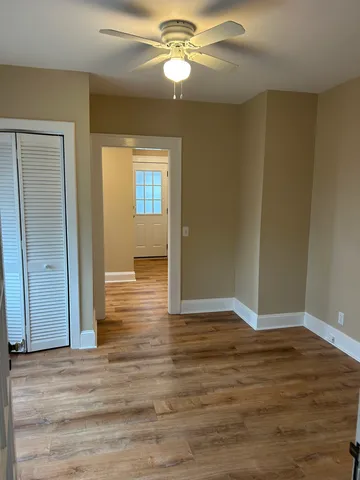 a view of empty room with wooden floor