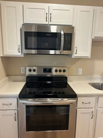 a kitchen with stainless steel appliances granite countertop a stove microwave and cabinets