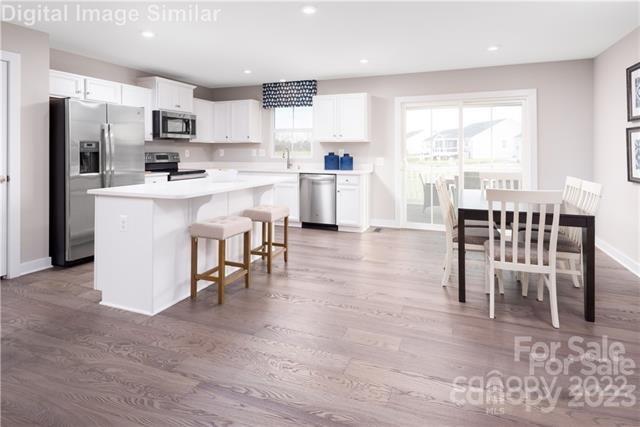 559 Grandiflora Avenue, Unit 108 Lancaster, SC 29720 - Photo 2 of 10 a kitchen with stainless steel appliances kitchen island granite countertop a table chairs microwave and sink